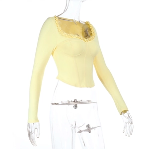 Detail of light yellow slim-fit top featuring ruffle neckline and fishbone structure