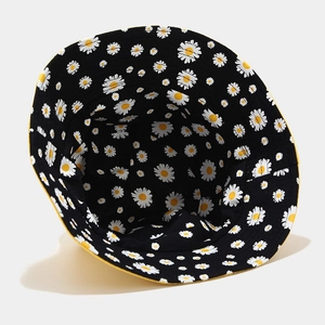 Detail of reversible daisy bucket hat with black floral print and yellow inner lining