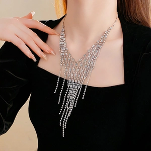 Close-up of a silver V-shaped fringe necklace with sparkling diamonds on a model