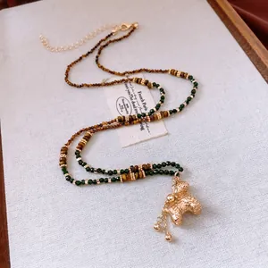 Collier vintage perles œil de tigre plaqué or avec pendentif chien et pompon élégant