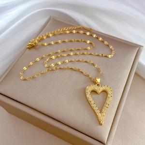 Detail of gold heart pendant with clear rhinestones on beige jewelry display box