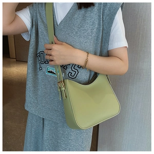 Détail d'une bandoulière réglable et boucle dorée sur un sac chic en similicuir vert