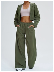 Detail of army green sun protection hooded jacket with front zipper and loose sport pants