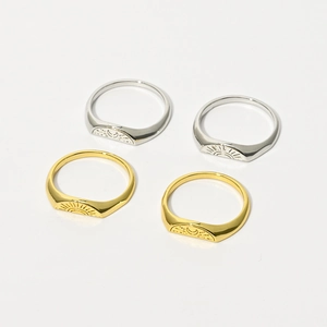 Close-up of polished 14k gold and silver rings with sunburst and crescent moon patterns