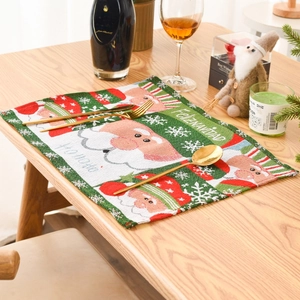 Detail of Christmas knitted placemat with Santa Claus and Feliz Navidad text on wood