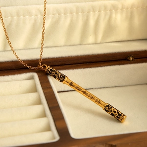 Vue détaillée du pendentif doré Ruyi Jingu Bang avec motifs de nuages sur velours