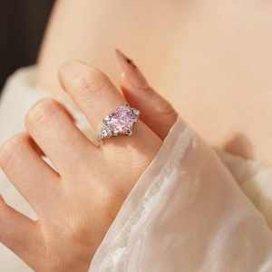 Close-up of heart-shaped pink zircon ring worn by a model with elegant silver details