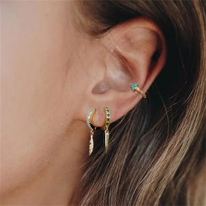 Close-up of S925 silver flower ear cuff and earrings with turquoise and feather charms