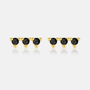 Close-up of gold s925 silver earrings with three black zircons in a row design