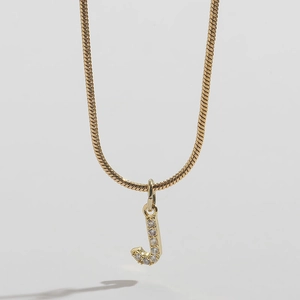 Close-up of 14k gold plated snake chain with sparkling rhinestone letter J pendant