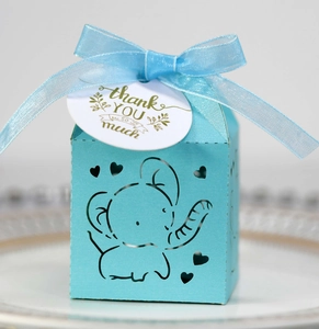 Detail of light blue laser-cut elephant candy box with silk ribbon and thank you tag