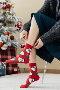 Details von roten Weihnachtsbaumwollsocken mit Schneemannmuster getragen von einem Model