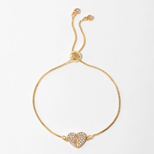 Detail of adjustable gold heart bracelet featuring a micro-paved broken heart charm