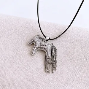 Silver horse pendant necklace with metal tassel fringe on a French Paris background
