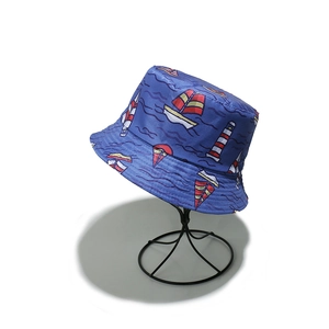 Detail of navy blue canvas bucket hat featuring nautical sailboat and lighthouse patterns
