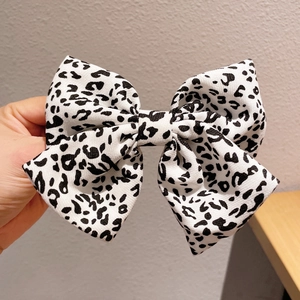 Detail showing high-quality leopard print fabric bow hairclip with spring mechanism