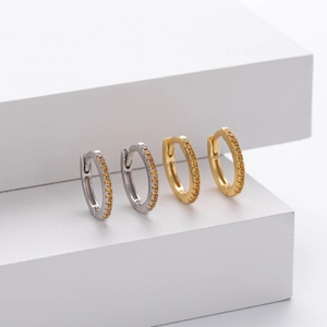 Close-up of S925 sterling silver hoop earrings with round amber stones in gold and silver
