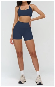 Detail of navy blue high-waist yoga shorts and halter sports bra with elastic fabric