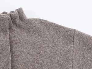 Close-up of tan knit bomber jacket collar and textured wool fabric detail
