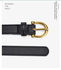 Detail of black lychee grain leather belt with gold horseshoe buckle for women