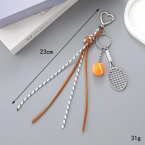 Close-up of tennis ball bag charm with braided rope and heart-shaped metal hook