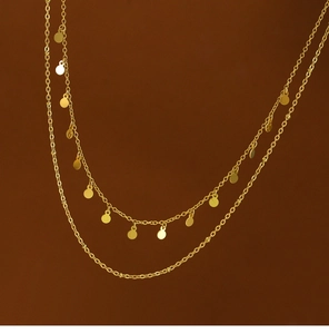 Detail of 18K gold plated double layer necklace with spotted geometric round charms