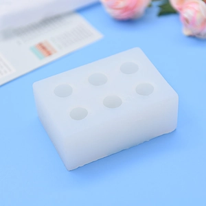 Rectangular white silicone mold with six cylindrical cavities for DIY craft baking projects