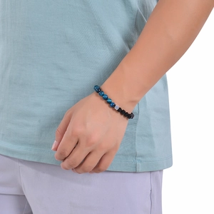 Close-up of blue tiger eye and matte black stone beaded bracelet on a person wrist