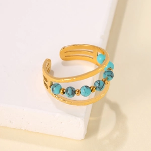 Macro view of a gold-plated multi-layer open ring with turquoise beads and retro details