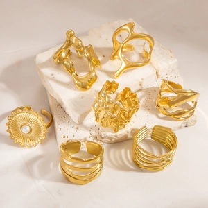 Detail of 18k gold plated stainless steel rings collection on white stone pedestal