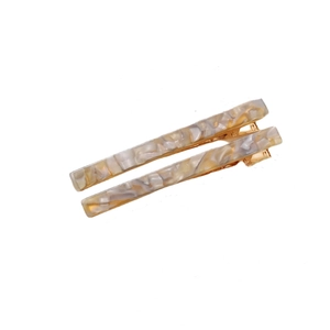 Close-up of marble acetate hair clips with gold alligator base on white background