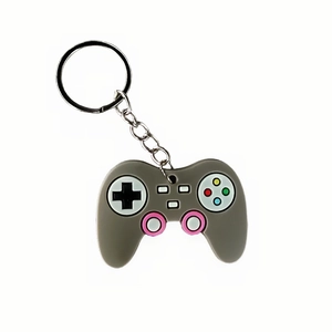 Detail shot of a grey PVC game controller keychain with colorful buttons on white background