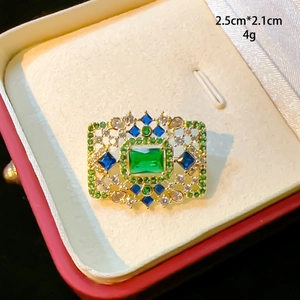 Broche fleur en cristal vert doré présentée dans un élégant écrin à bijoux en velours rouge