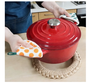 Polka dot fabric potholders used for lifting a red enamel pot lid in a clean kitchen scene