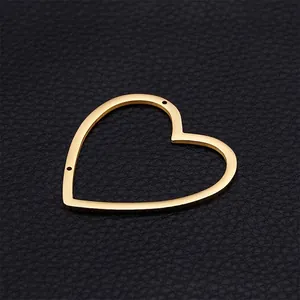 Gold plated stainless steel heart charm with cut-out design on black leather background