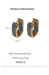 Macro view of U-shaped gold earrings with blue and green cubic zirconia inlay details