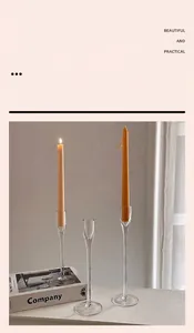 Close-up of high-borosilicate glass candle holders with elegant orange taper candles