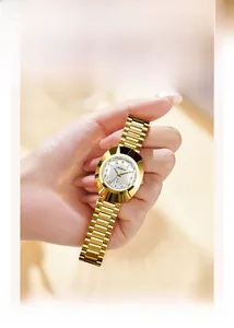 Detail of gold-tone women's watch with rhinestone markers and day-date display window