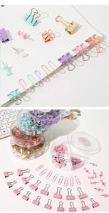 Macro view of pastel macaron binder clips and paperclips in a clear stationery set organizer