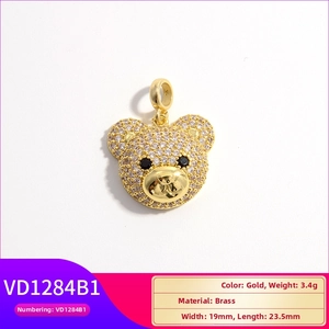 Golden bear pendant with sparkly crystals and black stone eyes on a white background