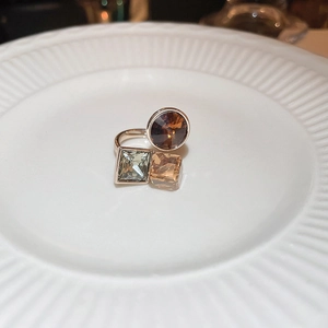 Detail of rose gold open ring featuring geometric colorful cubic zirconia stones