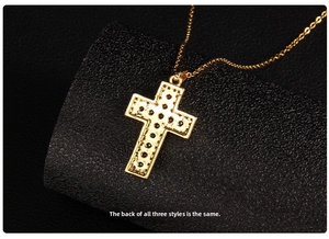 Macro shot of the polished gold cross pendant back featuring detailed dot embossing