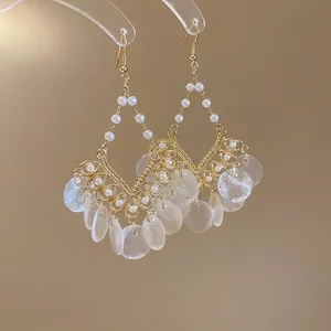 Bohemian gold tassel earrings with white pearls and translucent shell charms for beach style
