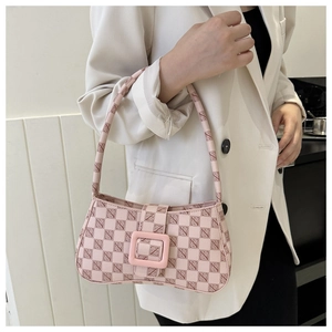 Detail of pink checkerboard underarm bag with monogram print and square buckle on model