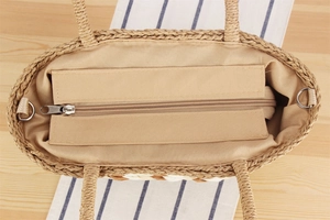 Detail of woven tote bag interior showing zipper closure, fabric lining and metal D-rings