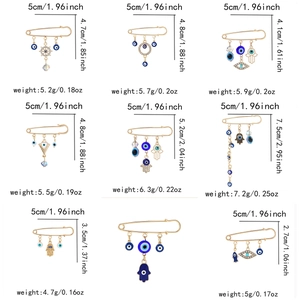 Detailed size chart for gold Evil Eye and Hamsa brooch pins with rhinestone accents