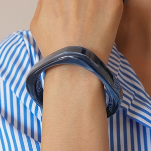 Close-up of translucent deep blue gradient resin bangle with wavy geometric structure