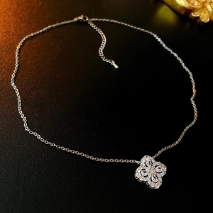 Detailed view of silver four-leaf clover pendant with sparkling zircon inlays