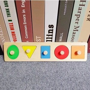 Close-up of colorful wooden geometric shapes with handles on a Montessori puzzle board