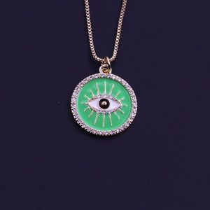 Close-up of gold-plated Evil Eye pendant with green enamel and sparkling rhinestones